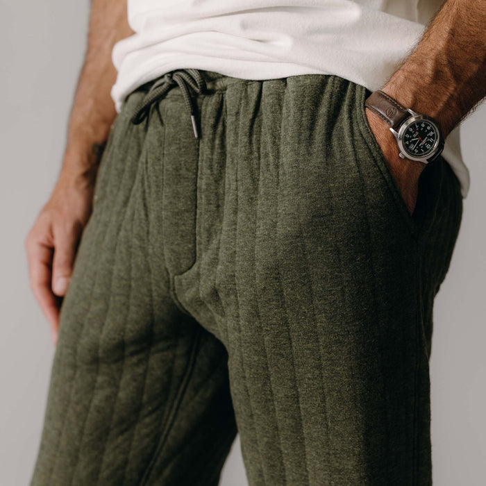 fit model with his hand in his pocket wearing The Quilted Apres Pant in Heather Fatigue Olive Jersey