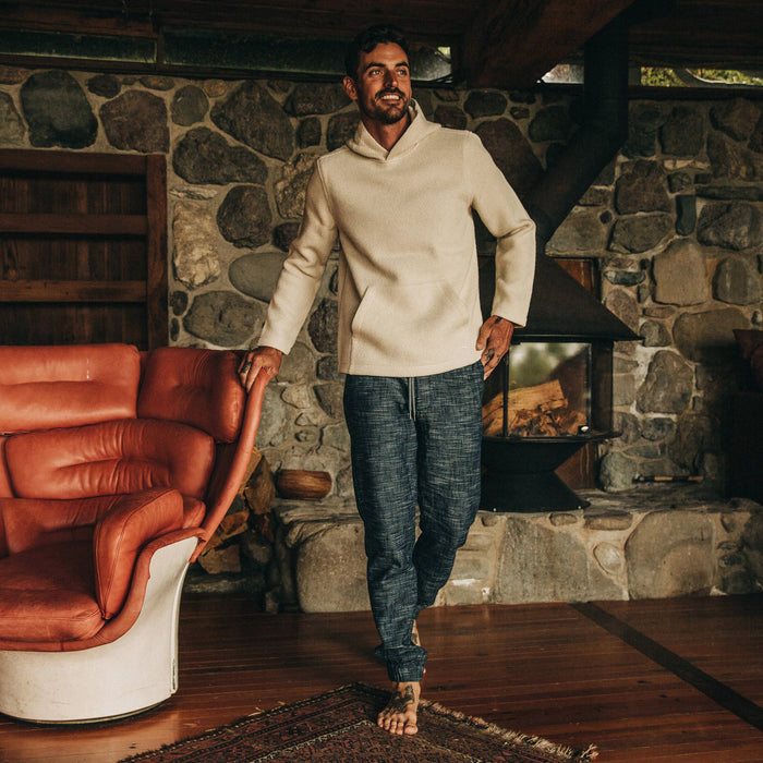 fit model wearing The Apres Pant in Indigo Slub, leaning against chair