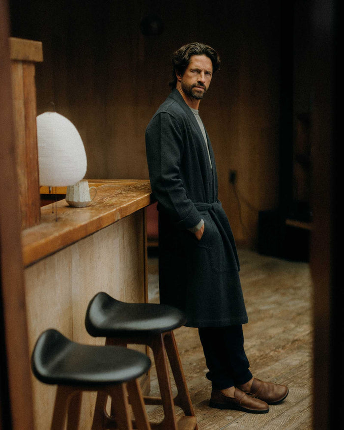 fit model leaning against the wall wearing The Apres Robe in Navy Sashiko