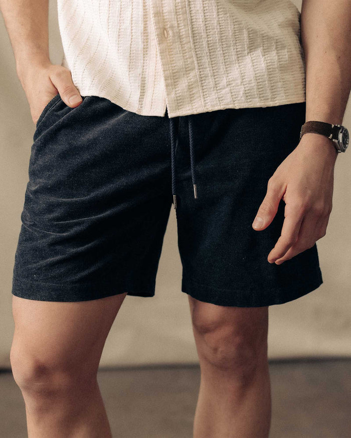 fit model with his hand in his pocket wearing The Apres Short in Heather Coal Pincord