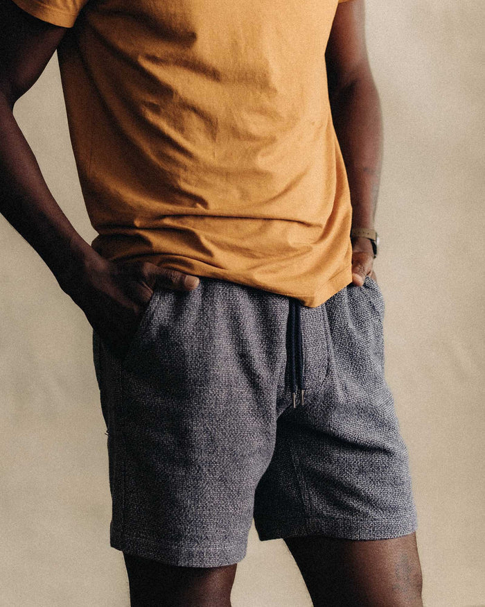 fit model with his hands in his pockets wearing The Apres Short in Navy Linen Tweed