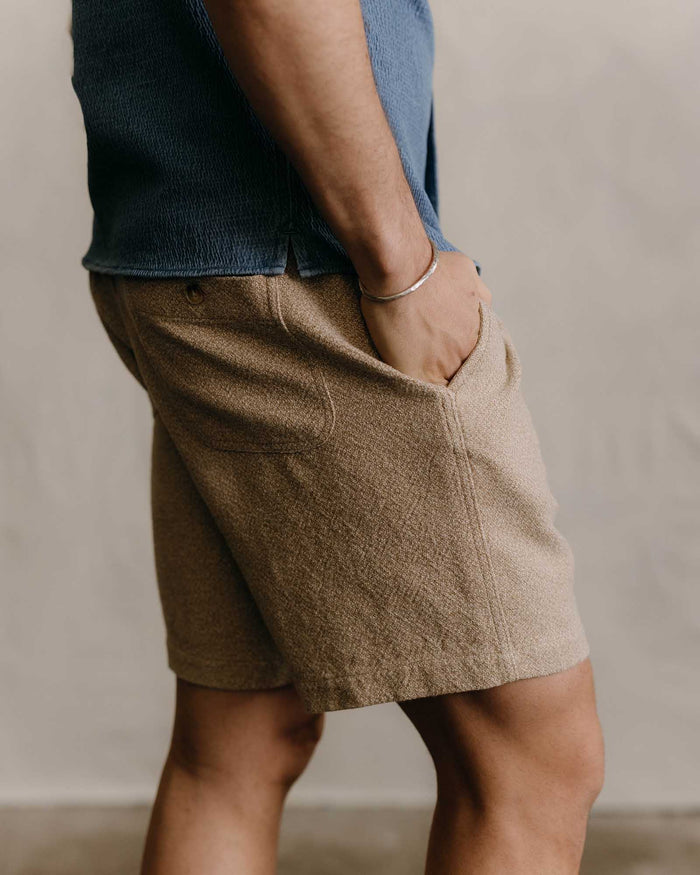fit model with his hands in his pockets wearing The Apres Short in Oat Linen Tweed