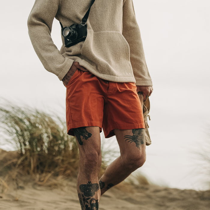 fit model walking on the beach in The Après Short in Rust Pinwale