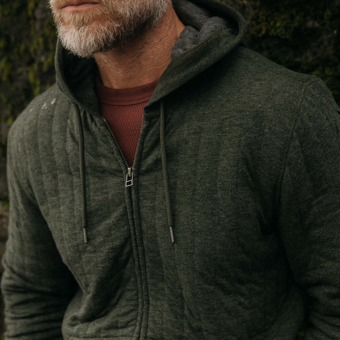 fit model drinking a coffee in The Apres Zip Hoodie in Fatigue Olive Quilt