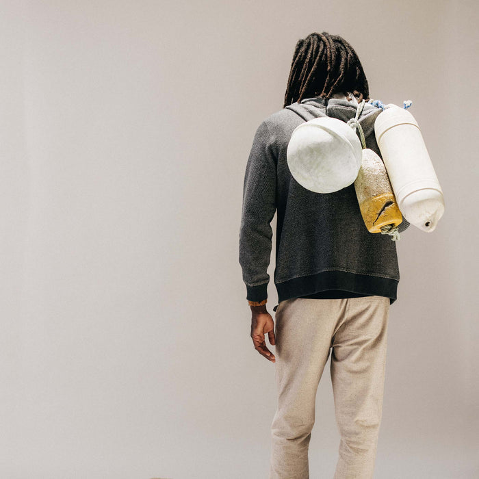 fit model holding buoys wearing The Apres Zip Hoodie in Graphite French Terry Twill