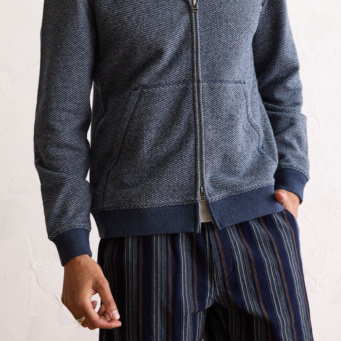 fit model showing the ribbing on The Apres Zip Hoodie in Heather Navy Terry