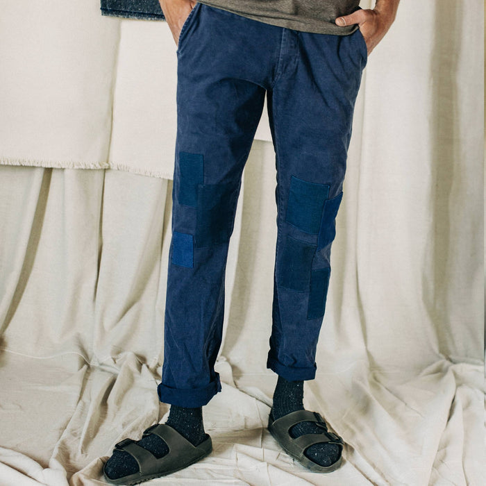 material shot of The Atelier and Repairs Chino in Navy, cuffed on model, in a studio