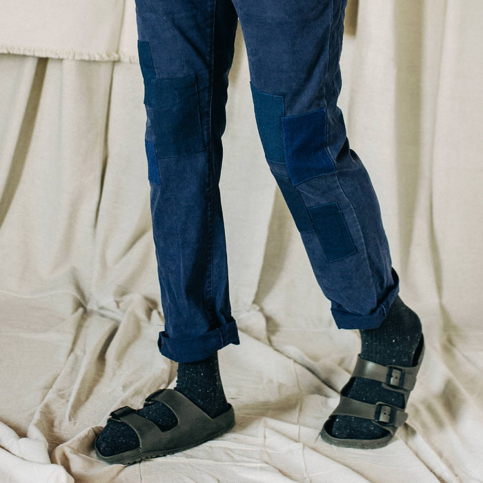 material shot of The Atelier and Repairs Chino in Navy, model standing diagonal