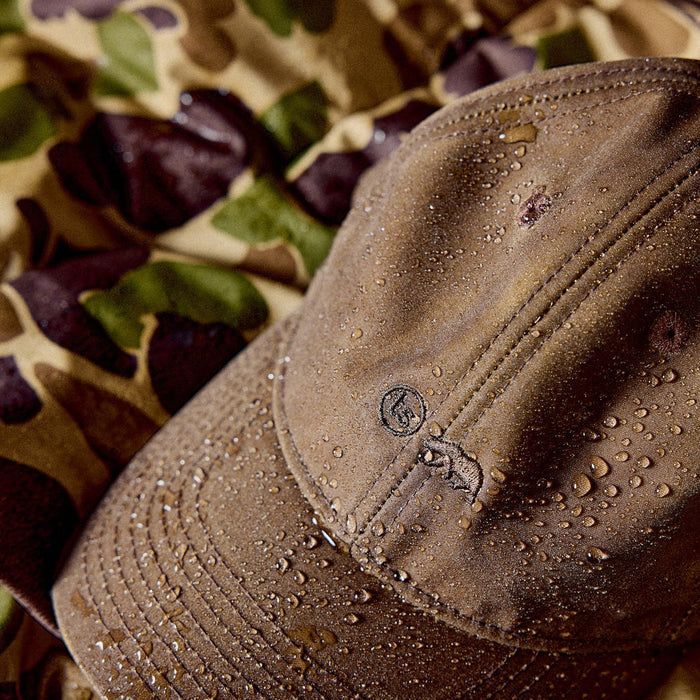 The Ball Cap in Dark Khaki Waxed Canvas with water droplets on it