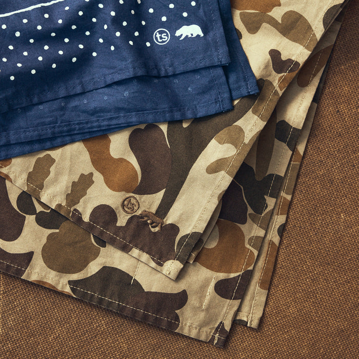 folded flatlay of The Bandana in Arid Camo next to another bandana