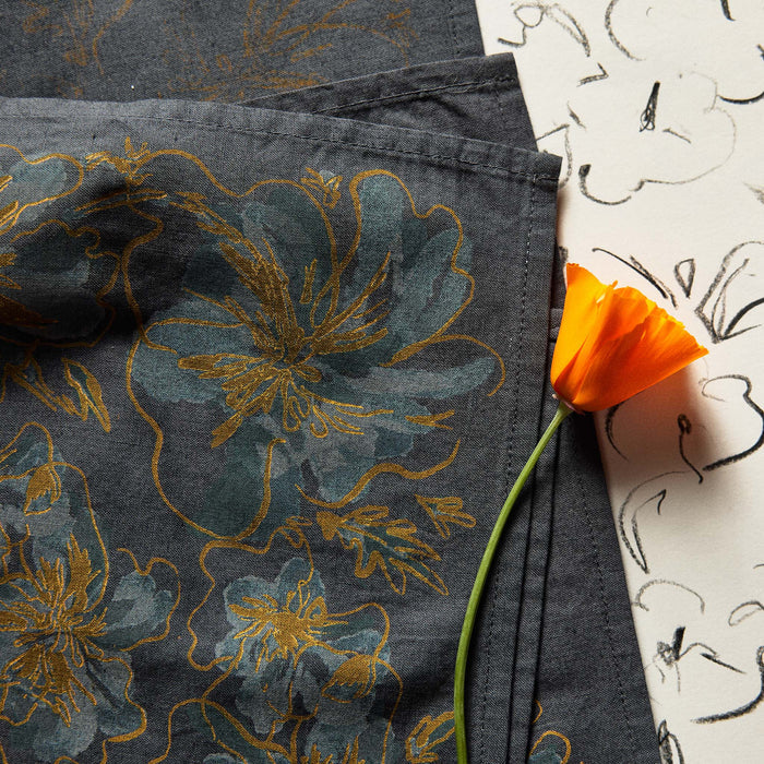 editorial image of the sides of The Bandana in Dark Blue Floral next to a flower