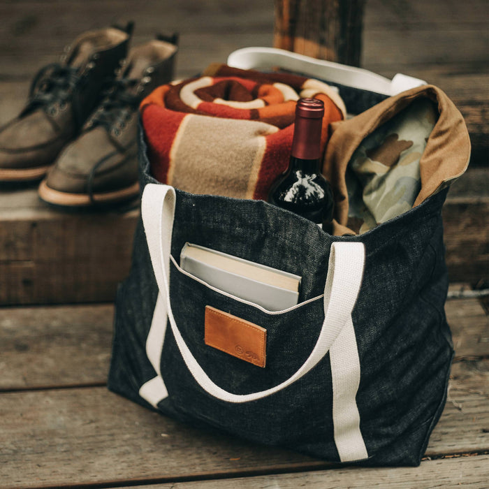 situational material shot of The Boat Tote in Cone Mills Selvage, wine and blanket inside