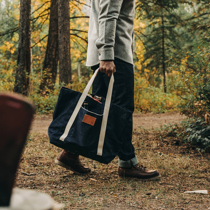 fit model rocking The Boat Tote in Cone Mills Selvage, walking in woods