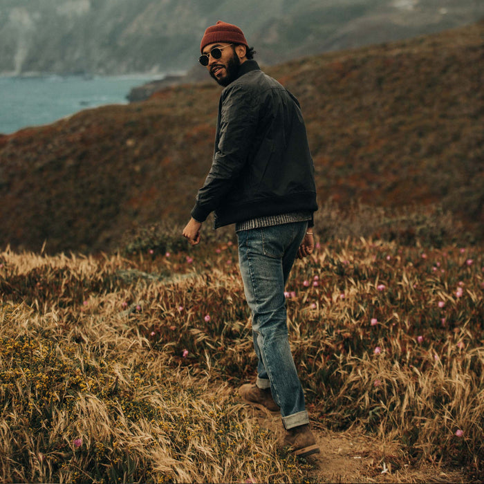 fit model looking back over his shoulder while wearing The Bomber Jacket in Waxed Navy