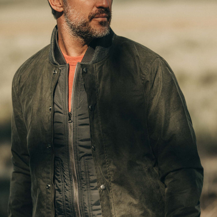 fit model wearing The Bomber Jacket in Waxed Olive looking over shoulder