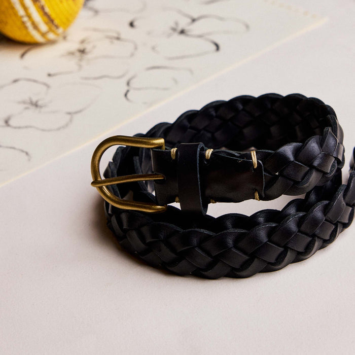 editorial image of The Braided Belt in Black rolled up on paper