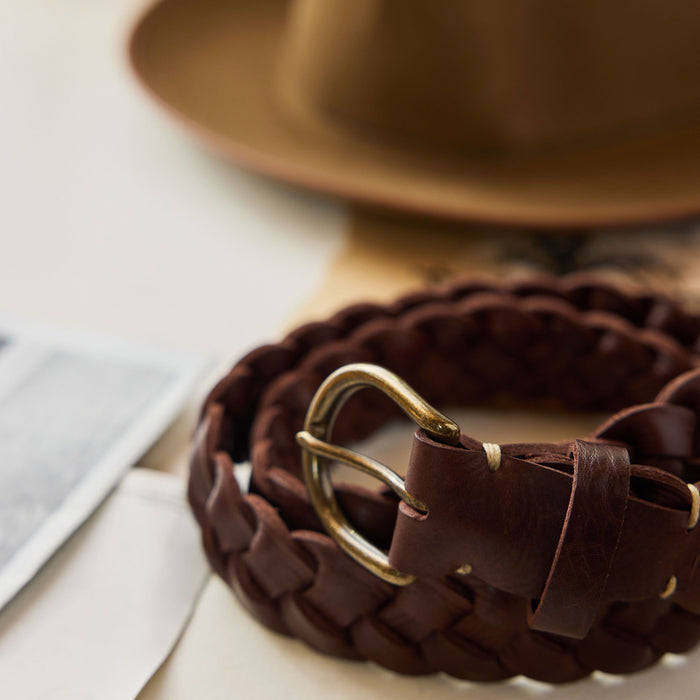 editorial image of The Braided Belt in Dark Brown rolled up on a piece of paper