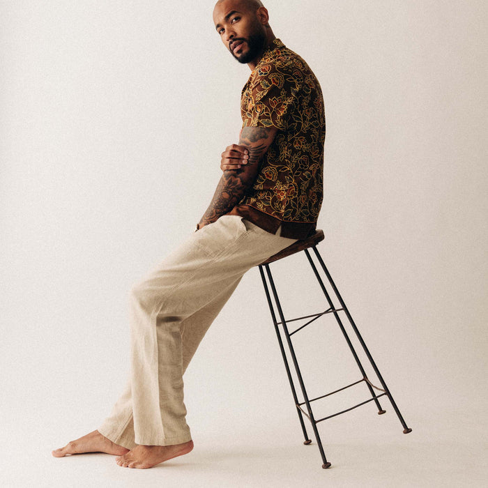 fit model sitting on a stool wearing The Breakwater Pant in Natural Herringbone