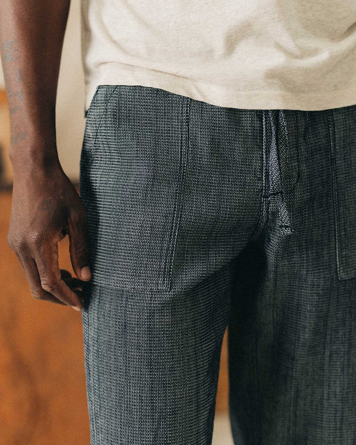 fit model showing off the pocket on The Breakwater Pant in Rinsed Indigo Stripe