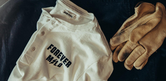 workshop header [tr] flatlay of our brother moto henley next to gloves