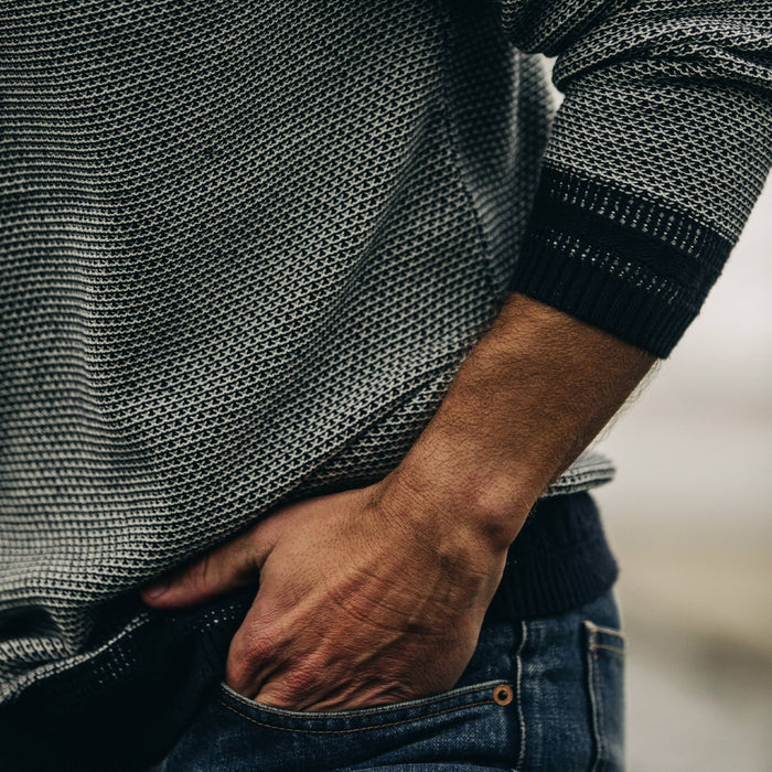 fit model with sleeve pulled up wearing The Brume Sweater in Navy Birdseye