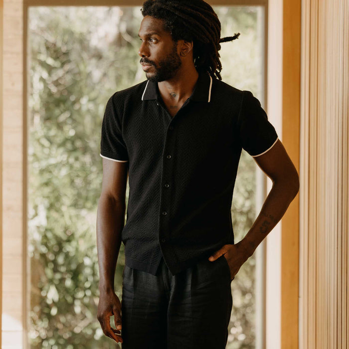 fit model with his hand in his pocket wearing The Button Down Polo in Coal Herringbone