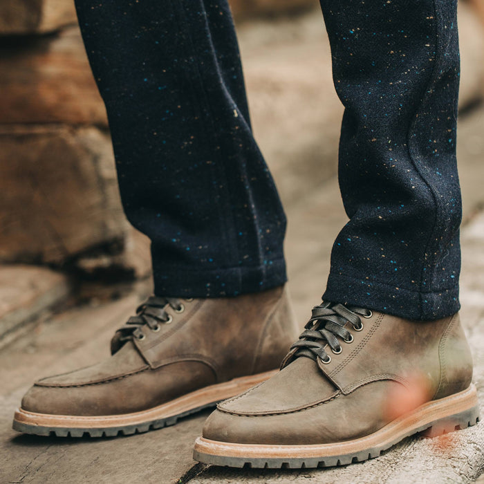 our fit model wearing The Camp Pant in Navy Donegal Herringbone—standing near shed, shot of pants with boots