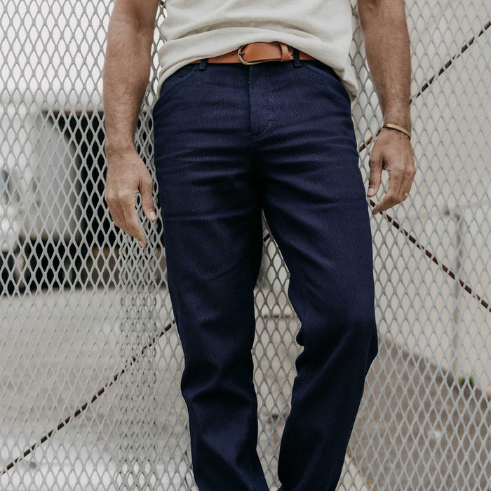 fit model leaning against the wall wearing The Camp Pant in Rigid Indigo Sashiko