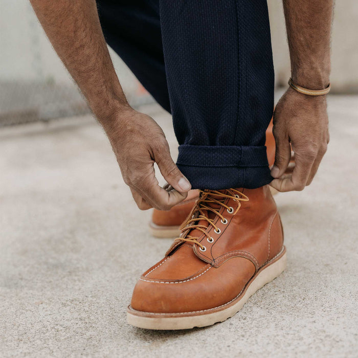 fit model adjusting the cuffs on The Camp Pant in Rigid Indigo Sashiko