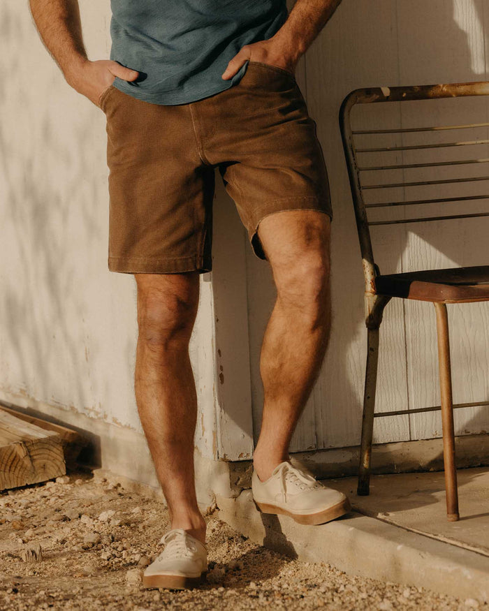 fit model leaning against the wall wearing The Camp Short in Aged Penny Chipped Canvas