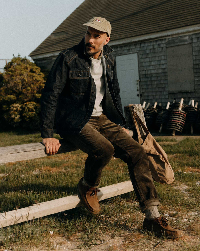 fit model sitting wearing The Carnegie Pant in Fatigue Olive Corduroy