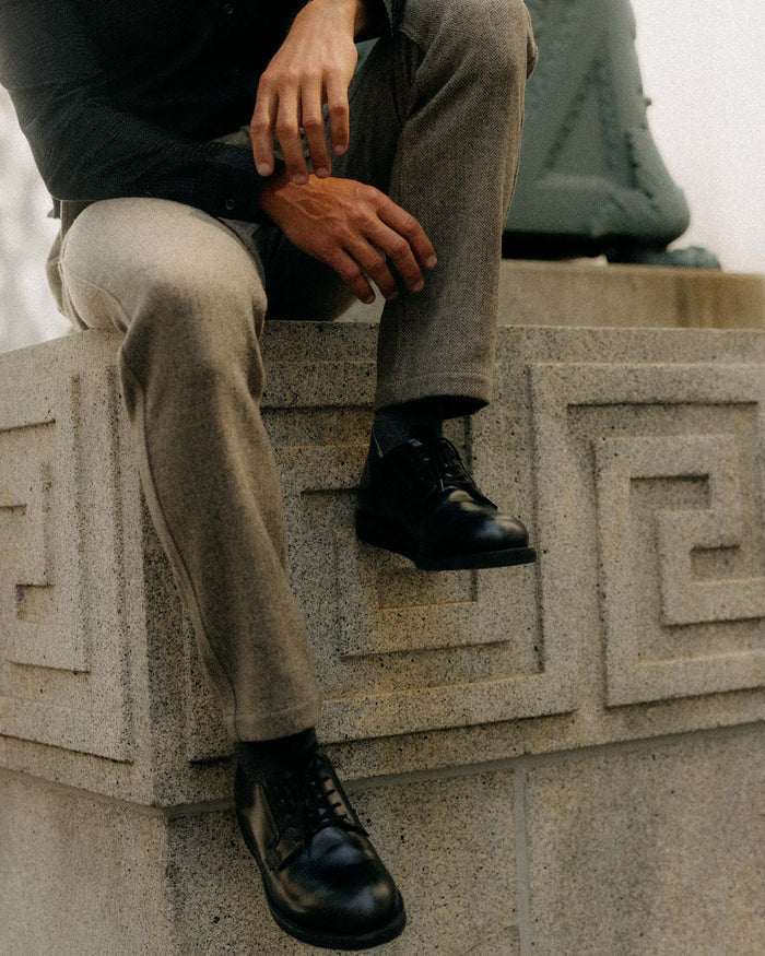 fit model sitting wearing The Carnegie Pant in Gravel Herringbone Wool