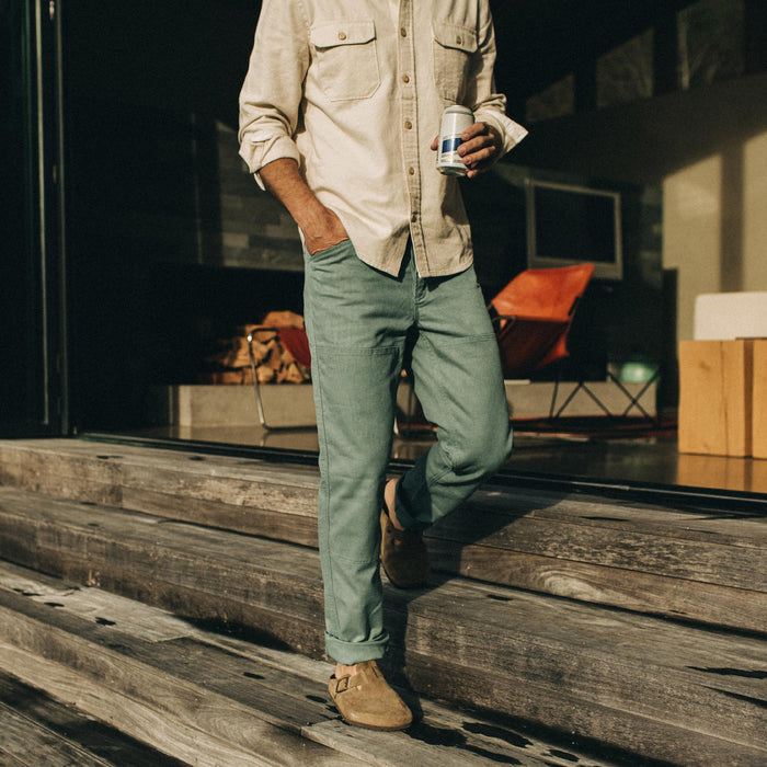 fit model wearing The Chore Pant in Ocean Boss Duck on the steps of a house