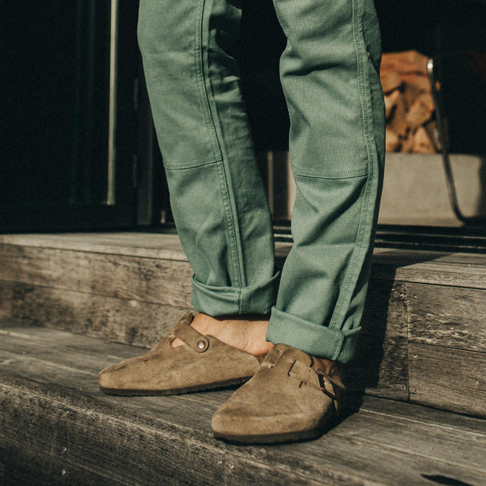 fit model standing on wooden steps in The Chore Pant in Ocean Boss Duck