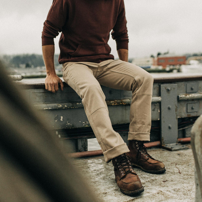 fit model sitting on the edge of a boat in The Chore Pant in Sand Boss Duck