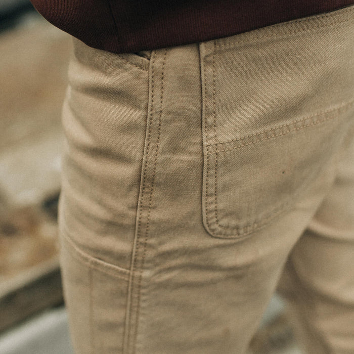 fit model standing in The Chore Pant in Sand Boss Duck, with the pocket detail showing