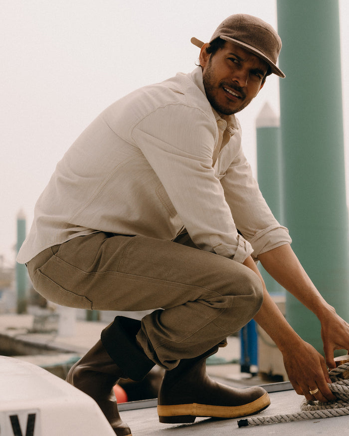 fit model leaning against the wall wearing The Chore Pant in Stone Chipped Canvas
