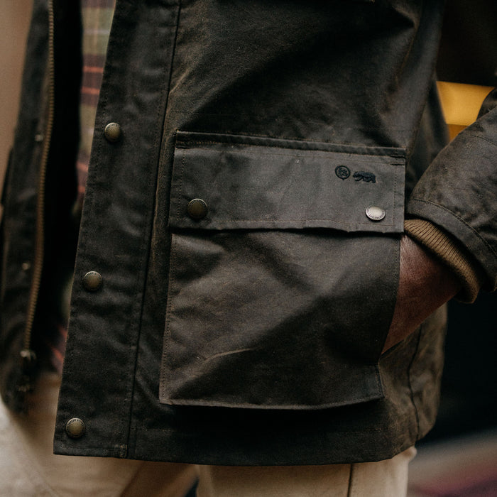 fit model showing the pockets on The Clutch Jacket in Soil Waxed Canvas