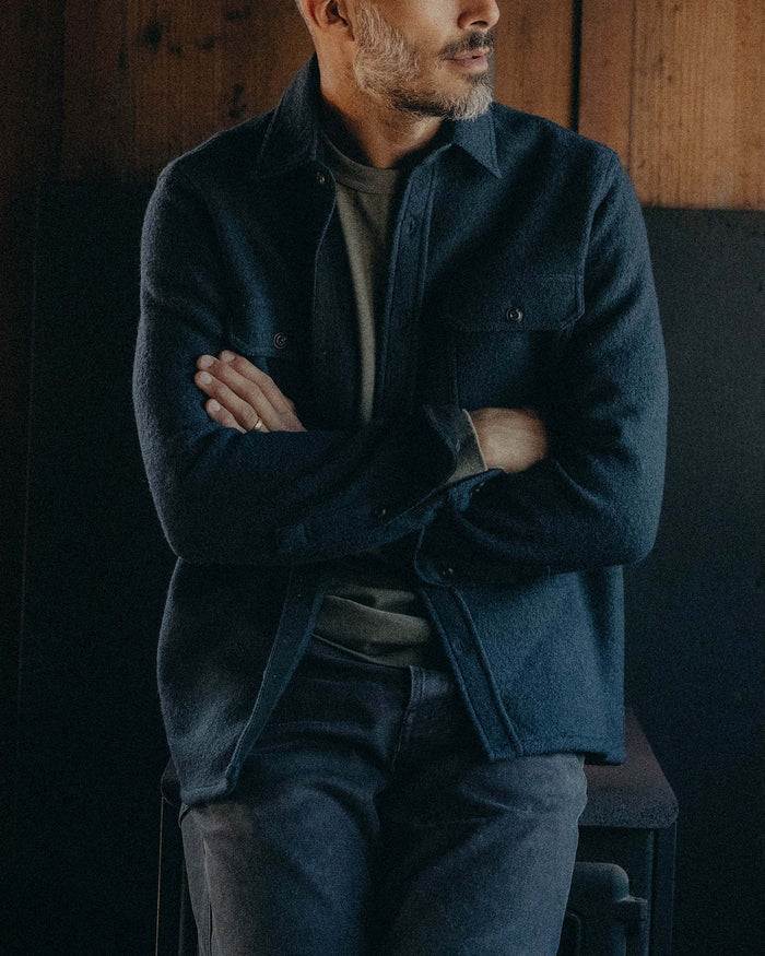 fit model leaning against the wall wearing The Connor Overshirt in Dark Navy Boucle