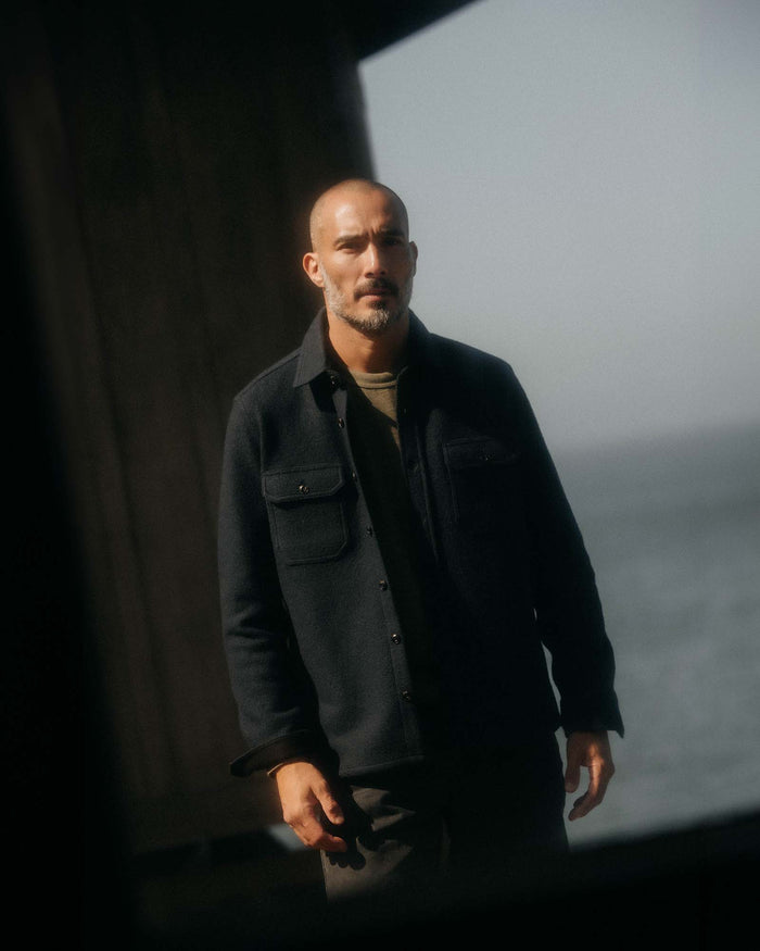 fit model adjusting the cuffs wearing The Connor Overshirt in Dark Navy Boucle