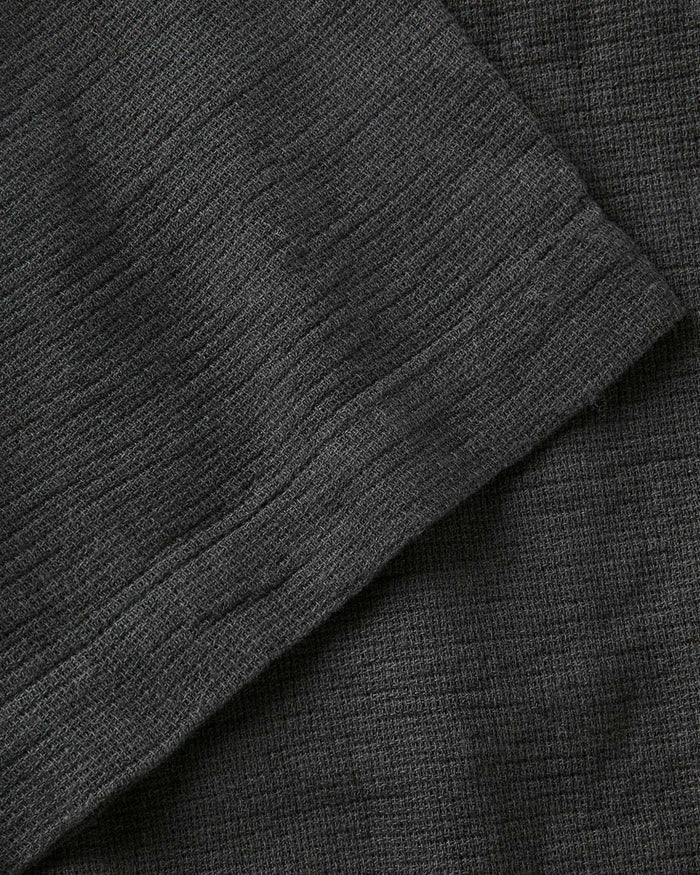 fit model showing off the buttons on The Conrad Shirt in Faded Black Linen