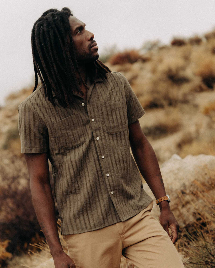 fit model walking wearing The Conrad Shirt in Fatigue Olive Dobby Stripe
