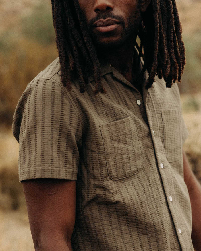 fit model showing off the pockets on The Conrad Shirt in Fatigue Olive Dobby Stripe