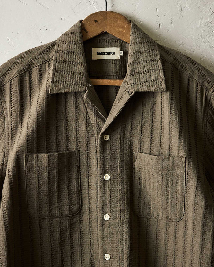 editorial image of The Conrad Shirt in Fatigue Olive Dobby Stripe hanging