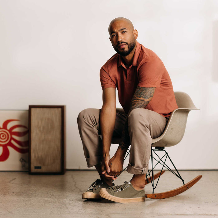 fit model sitting wearing The Cotton Hemp Polo in Fired Clay