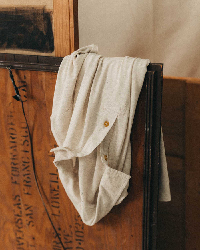 fit model with his hands in his pockets wearing The Cotton Hemp Polo in Heather Oat