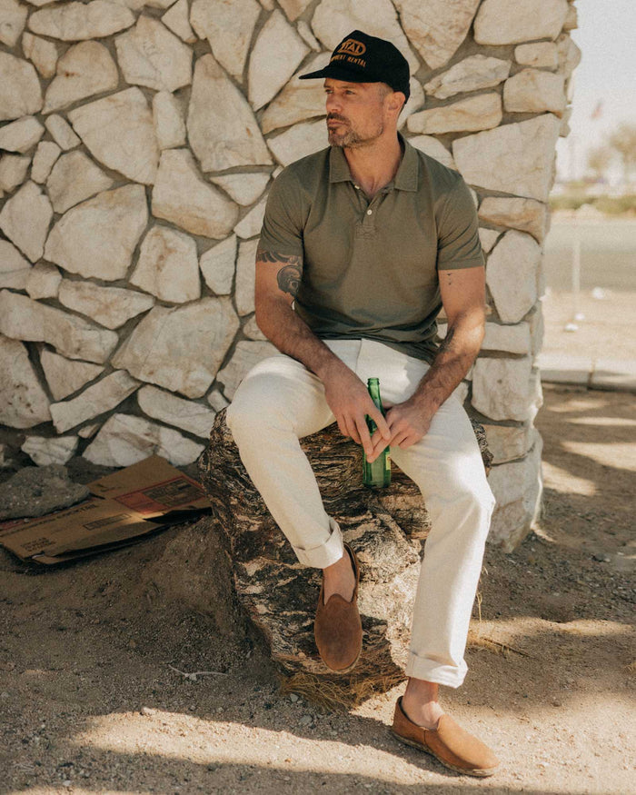 fit model sitting wearing The Cotton Hemp Polo in Olive