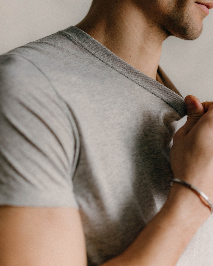 fit model showing off logo detail on The Cotton Hemp Tee in Heather Grey