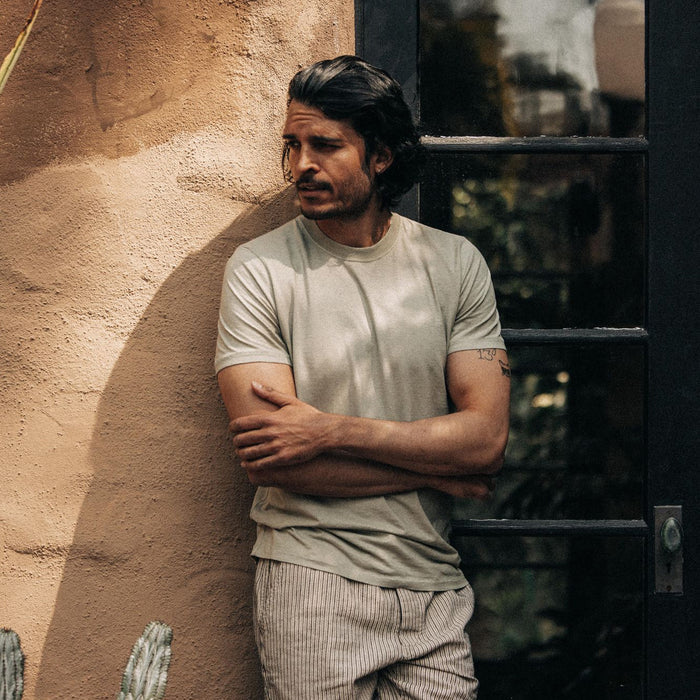 fit model leaning against the wall wearing The Cotton Hemp Tee in Sage