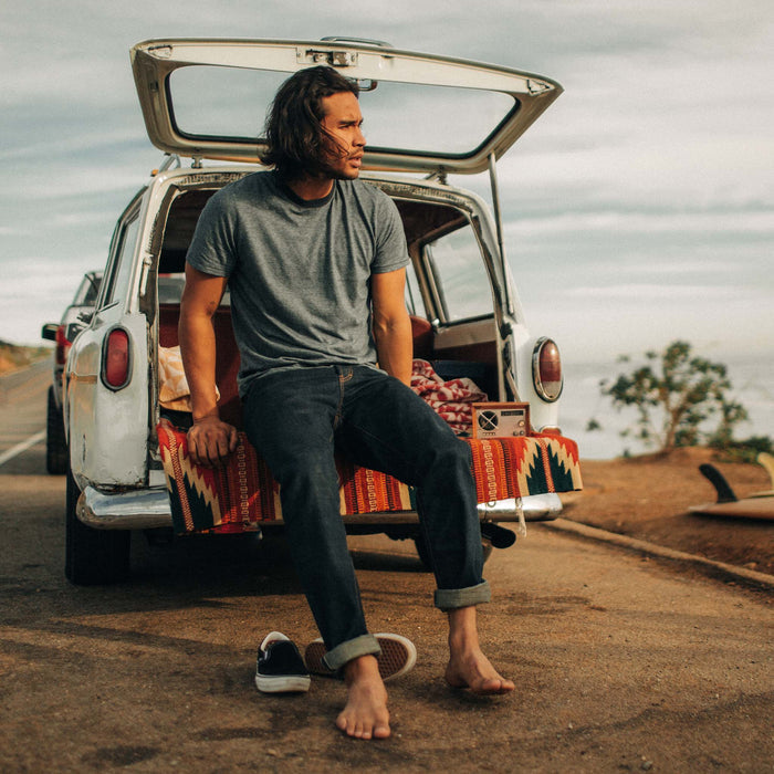 fit model sitting in a car wearing The Cotton Hemp Tee in Slate and Navy Stripe